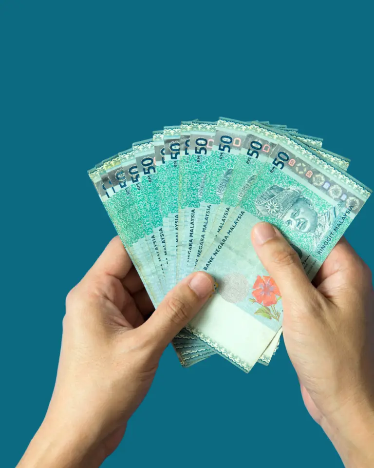 Hands holding Malaysian Ringgit notes